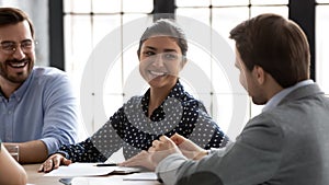 Smiling diverse colleagues have fun brainstorming at office meeting