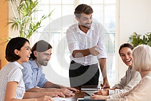 Smiling multiracial colleagues brainstorm at office meeting