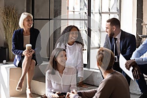 Smiling multiracial colleagues have fun at work break