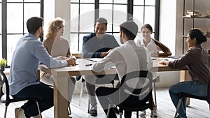 Smiling multiracial employees have fun brainstorming at meeting