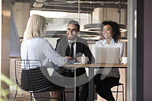 Smiling multiracial employers laugh talking with job candidate in office