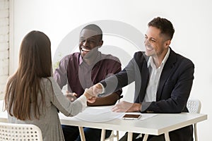 Smiling hr handshaking female applicant at job interview, hiring