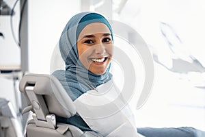 Smiling Muslim Female Patient Sitting At Dentist Chair, Waiting For Check Up