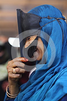 Smiling muslim woman with traditional mask