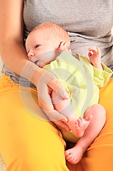 Smiling newborn baby boy on momÂ´s lap