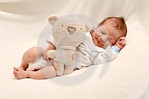 Smiling Newborn Baby Boy Sleeping with Teddy bear