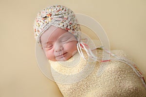 Smiling Newborn Baby Girl Swaddled in Yellow