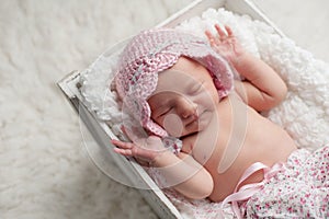 Smiling Newborn Baby Girl Wearing a Pink Bonnet