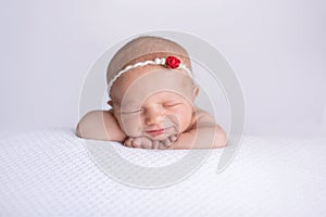 Smiling Newborn Baby Girl Wearing a Red Rose Headband