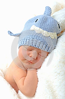 Smiling newborn baby in shark hat