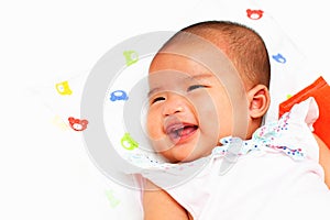 Smiling newborn infant baby girl on white bed