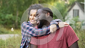 Smiling newly married couple celebrate buying new cottage in countryside