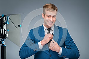 Smiling newsman adjusting the microphone