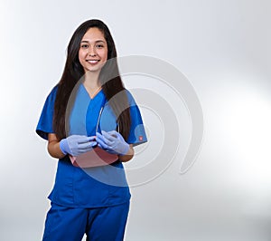 Smiling Nurse in Blue Scrubs Holding Bedpan