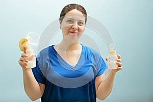 Smiling nurse is holding breast pump, bottle of milk. mixed feeding, preserving lactation of working mom. Help with breastfeeding,