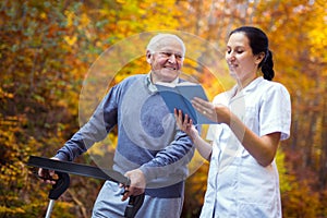 Smiling nurse reading book to senior man