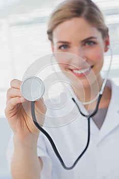 Smiling nurse showing her stethoscope