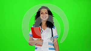 Smiling nurse with stethoscope and medical journal