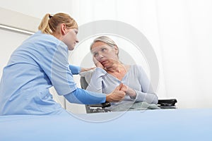 Smiling nurse take comfort elderly woman isolated on wheelchair near bed in hospital room, concept of loneliness and old age