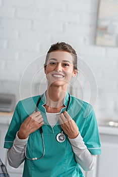 Smiling nurse in uniform holding stethoscope