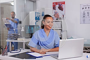 Smiling nurse using laptop computer