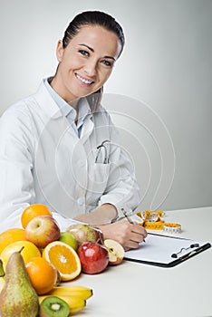 Smiling nutritionist writing medical records photo