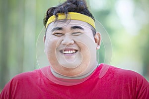 Smiling obese man wears sportswear in park