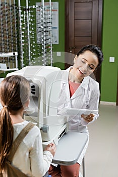 smiling oculist with digital tablet testing