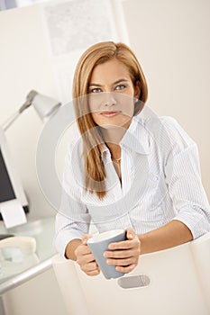 Smiling office worker having tea