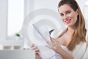 Smiling office worker holding documents