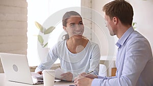 Smiling office workers working together on paperwork talking handshaking