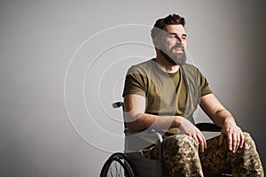 Smiling officer wearing uniform and sitting in a wheelchair