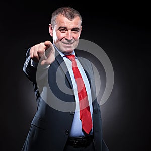 Smiling old business man pointing his finger