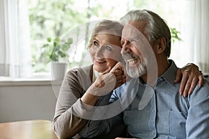 Smiling old couple hug dreaming of healthy future