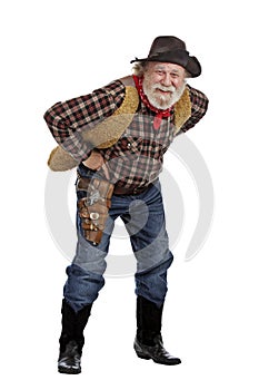 Smiling old cowboy stands leaning forward