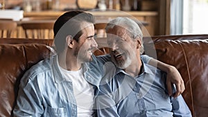 Smiling old father and adult son enjoy family weekend