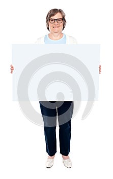 Smiling old lady holding blank whiteboard