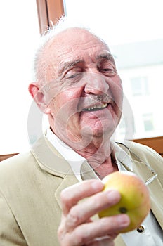 Smiling old man with apple