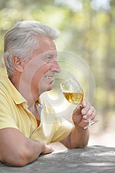Smiling old man drinking wine
