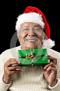 Smiling Old Man Handing Over A Wrapped Green Gift