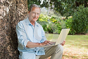 Smiling old man with a laptop