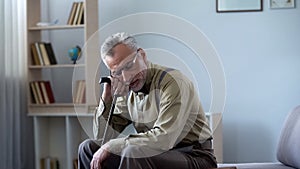 Smiling old man leaning on walking stick, taking nap after lunch, healthy habit