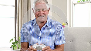 Smiling old man playing video game