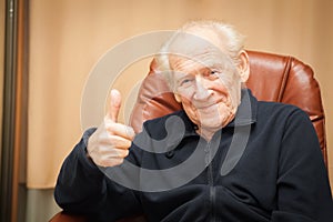 Smiling old man showing thumbs up