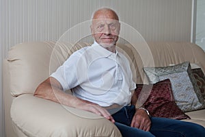 Smiling old man sitting on sofa