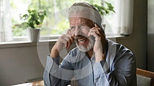 Smiling old man talk on smartphone laughing