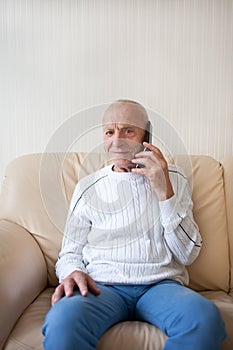 Smiling old man is talking on the phone