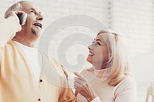 Smiling Old Man and Woman Talking on Smartphone.