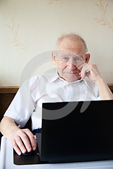 Smiling old man working on a computer