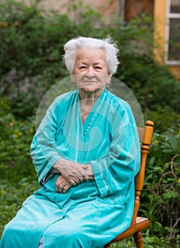 Smiling old womansitting on a chair